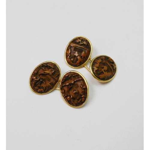 82 - A pair of Chinese chain link cufflinks comprising four similar oval carved nut urban views in unmark... 