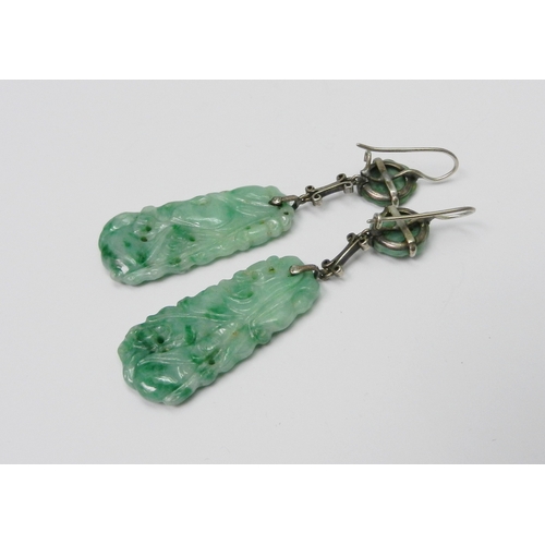 84 - A pair of jade panel earrings each comprising a rectangular and circular carved panels suspended and... 