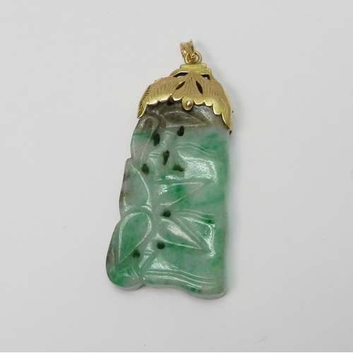 93 - A mottled jade pendant carved with a bamboo motif design, having an unmarked yellow metal 