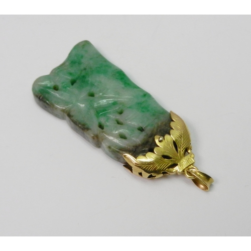 93 - A mottled jade pendant carved with a bamboo motif design, having an unmarked yellow metal 