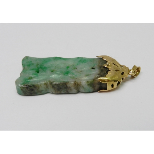 93 - A mottled jade pendant carved with a bamboo motif design, having an unmarked yellow metal 