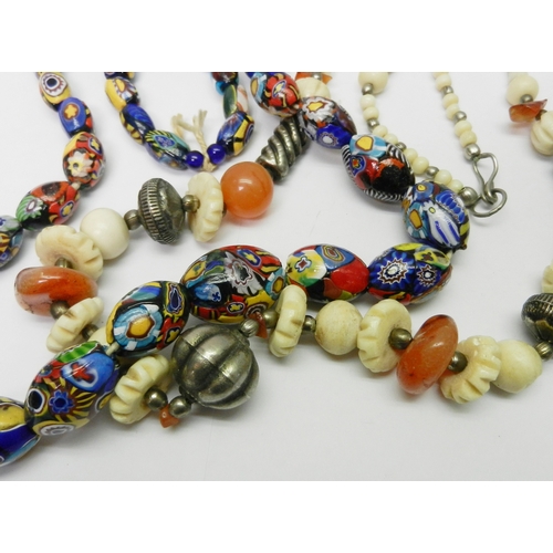 143 - Five bead necklaces incl a carnelian, bone and white metal example believed African, and a millefior... 