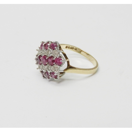 170 - A cluster ring comprising three lines of round cut synthetic pink stones spaced with two lines of il... 