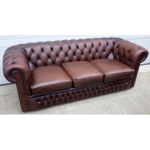 605 - A brown button leather chesterfield sofa, 205cm wide, piping a/f