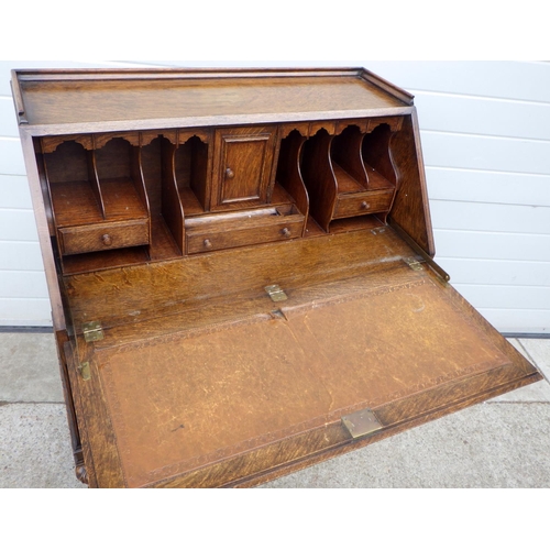 626 - A 1930's panelled oak bureau, 89cm wide