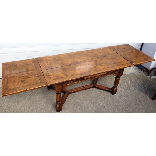 An oak draw leaf table, top cracked & loose together with twelve matched spindle back chairs (13) (a/f worm)