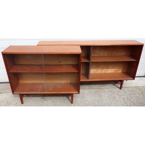 676 - Two teak low bookcases with sliding glass doors, largest 153cm wide