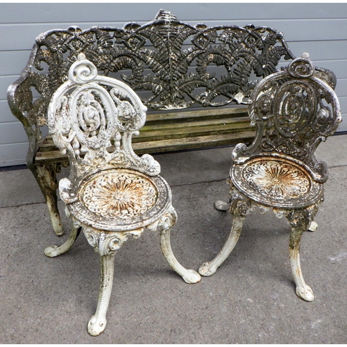 704 - A heavy cast iron garden bench together with two similar cast iron chairs (3)