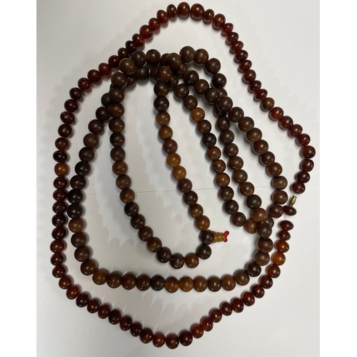 273 - A necklace comprising a single string of circular Oriental beads 1400mm long; another bead necklace.