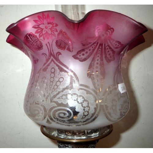 336 - An early 20thC oil lamp with cranberry shade