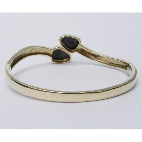 43 - A bangle of torque design having a double hinge opening, each terminal containing a pear-shaped opal... 