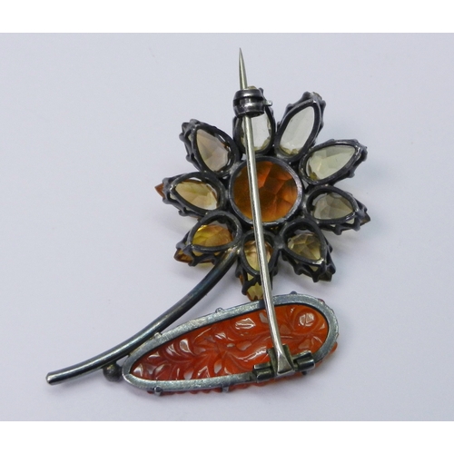51 - A brooch modelled as a single stem flower, unmarked white metal incorporating a Chinese carved hards... 