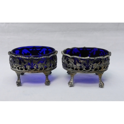 9 - A pair of George III silver and blue glass Rococo revival table salts standing on four claw feet, Da... 
