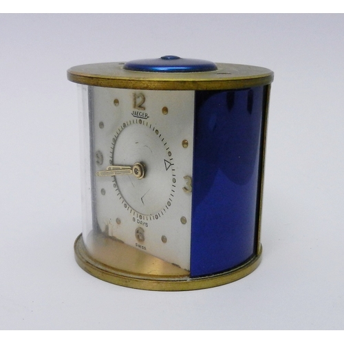 81 - A Jaeger desk / bedside alarm clock comprising an 8 day manual wind movement in a brass and blue ano... 