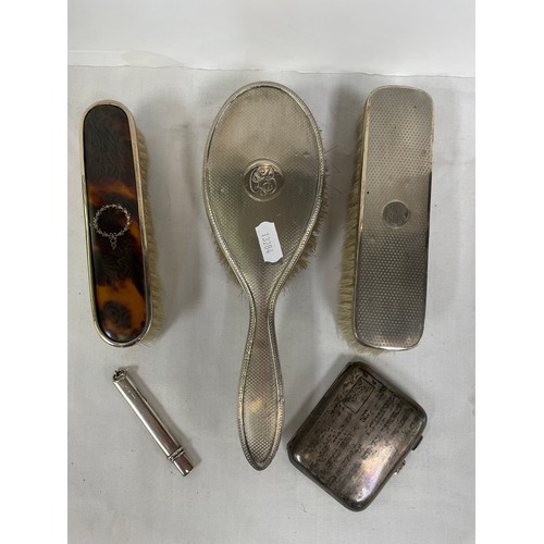 79 - Three various silver backed hair brushes; a silver cigarette case; a silver pencil.