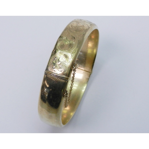 107 - A hinge bangle, 9ct gold late 20th cent.  A/F dented.  59mm interior diameter at hinge / 17g