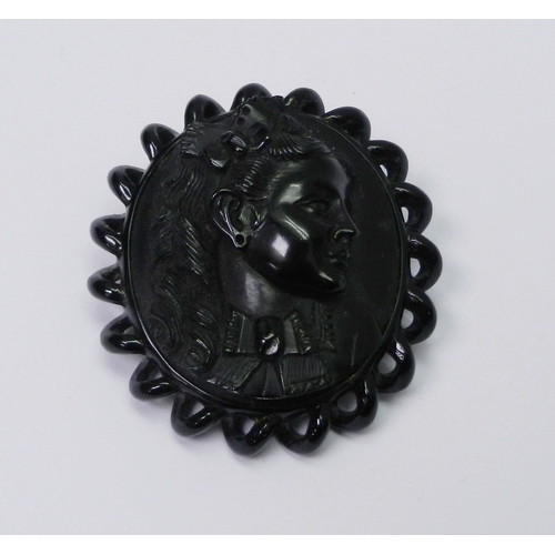 65 - A cameo brooch depicting a young woman in  3/4 profile, carved jet bearing initials / signature 