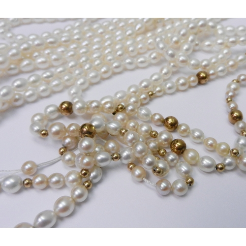 57 - A necklace comprising a single string of pearls spaced with yellow metal beads, whole a/f end clasps... 