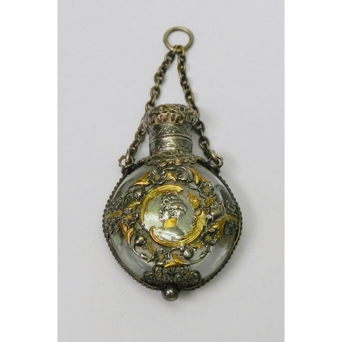 131 - A scent bottle cut rock crystal having white metal mounts with gilt details incorporating a central ...