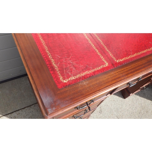 713 - A reproduction mahogany red leather topped pedestal desk and filing cabinet (2)