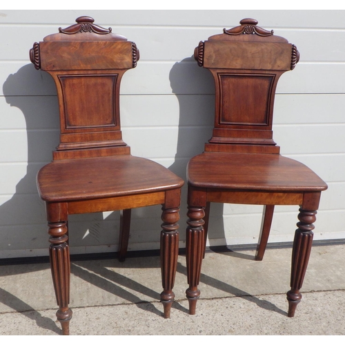 715 - A pair of Regency mahogany hall chairs on reeded legs, in the manner of Gillow a/f repairs, replaced...