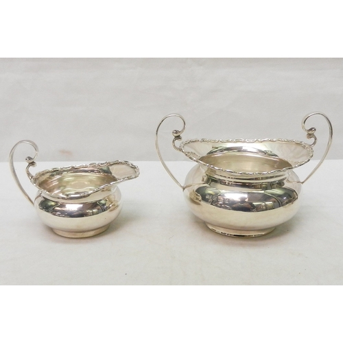 18 - A matching silver jug and two-handled sugar basin; a pair of silver toast racks.  Jug 85mm long incl... 