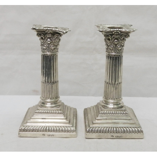 27 - A pair of silver Corinthian column candlesticks, early 20th cent.  155mm tall.  A/F