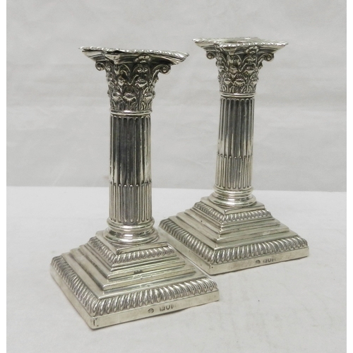 27 - A pair of silver Corinthian column candlesticks, early 20th cent.  155mm tall.  A/F