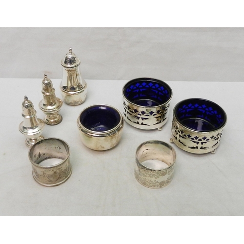 65 - Silver condiments incl a pair of table salts and a pair of pepper pots; two napkin rings.  230g