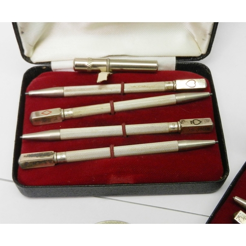 76 - Two cased sets of four bridge marker pencils, white metal marked Sterling; three commemorative coins... 