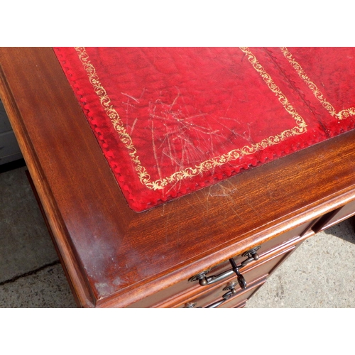 713 - A reproduction mahogany red leather topped pedestal desk and filing cabinet (2)