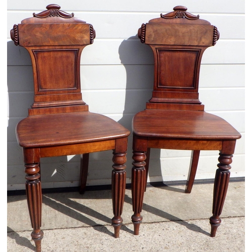 715 - A pair of Regency mahogany hall chairs on reeded legs, in the manner of Gillow a/f repairs, replaced... 