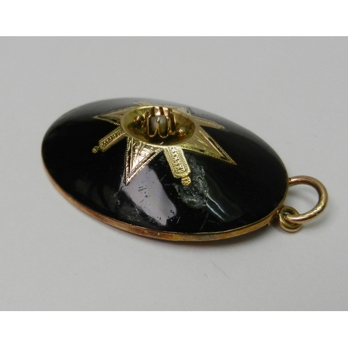 60 - An oval mourning pendant, black enamel on yellow metal having a central seed pearl in a claw setting... 