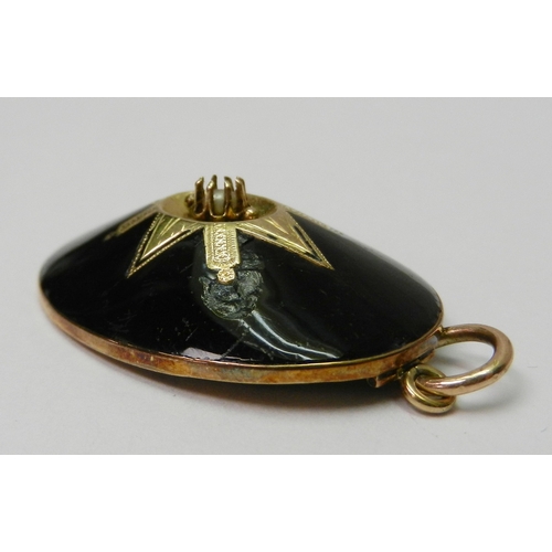 60 - An oval mourning pendant, black enamel on yellow metal having a central seed pearl in a claw setting... 