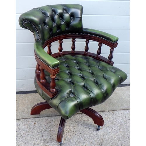 829 - A buttoned green leather office swivel chair, seat sloping