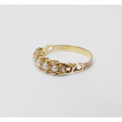 32 - A ring comprising seven graduated pearls in an unmarked yellow metal setting.