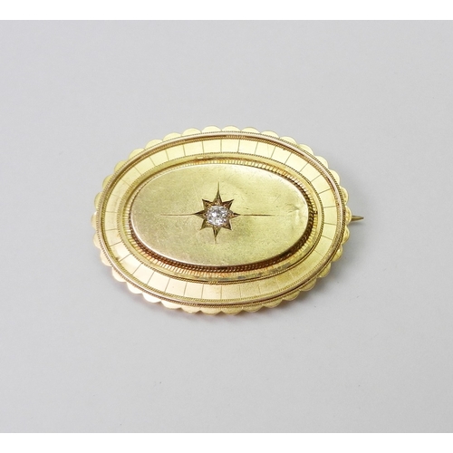 34 - A Victorian Etruscan Revival influence oval brooch comprising a central diamond in an indistinctly m... 