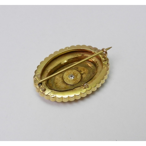 34 - A Victorian Etruscan Revival influence oval brooch comprising a central diamond in an indistinctly m... 