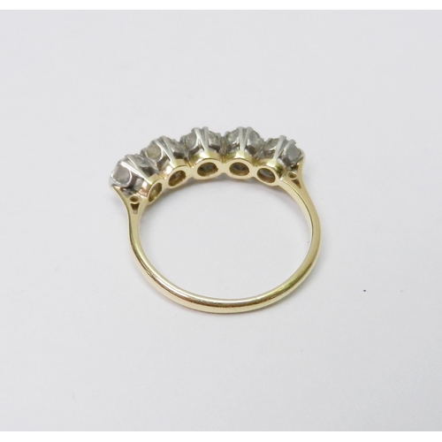 39 - A five stone ring comprising five evenly sized round cut diamonds set in white metal raised claws on... 