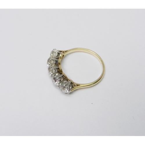 39 - A five stone ring comprising five evenly sized round cut diamonds set in white metal raised claws on... 