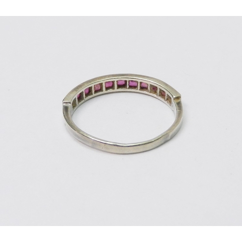 50 - A half hoop ring, 9ct white gold set with eleven square cut rubies, 1.5g / SIZE.