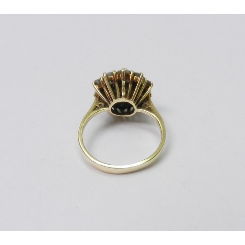 56 - A diamond cluster ring comprising a principal round cut stone in a raised claw setting surrounded by... 