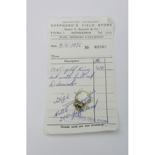 56 - A diamond cluster ring comprising a principal round cut stone in a raised claw setting surrounded by... 