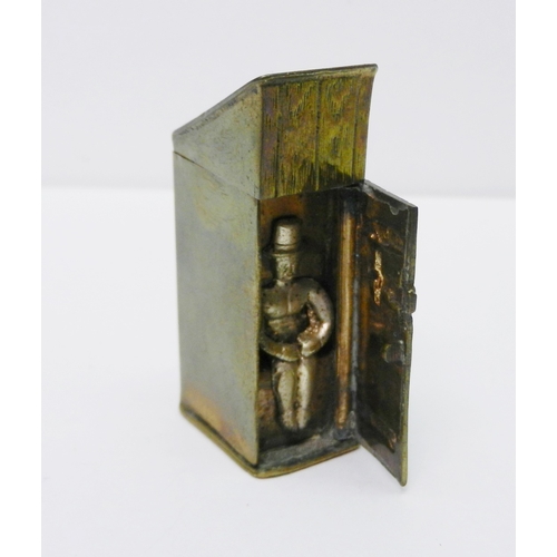 123 - A novelty vesta case modelled as a man in a top hat sitting in an outhouse, brass / base metal, 50mm... 