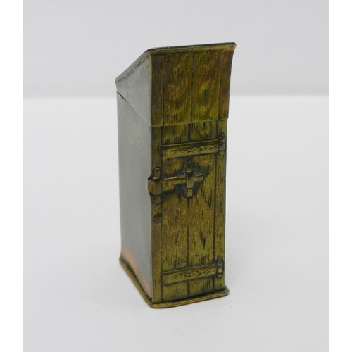 123 - A novelty vesta case modelled as a man in a top hat sitting in an outhouse, brass / base metal, 50mm... 