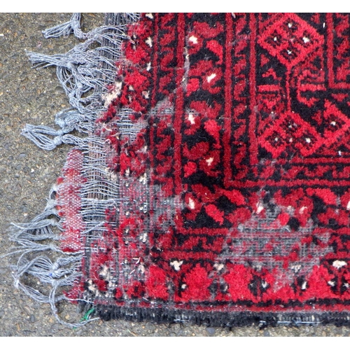 863 - A red ground carpet, moth damage, approx 290cm x 200cm together with a smaller red ground rug (2)