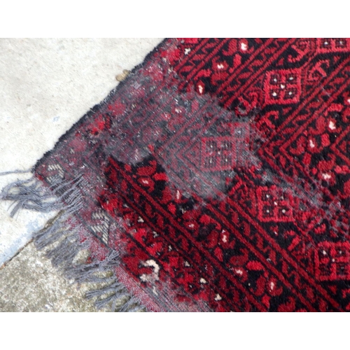 863 - A red ground carpet, moth damage, approx 290cm x 200cm together with a smaller red ground rug (2)