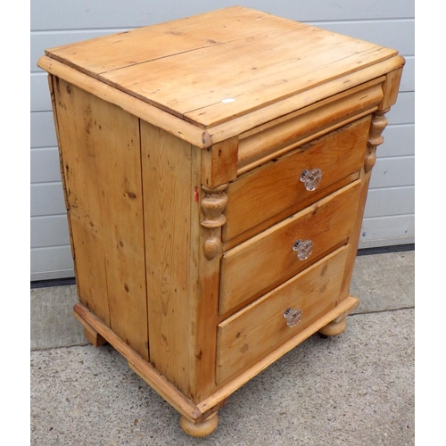 880 - A stripped pine three drawer chest with glass handles, cracks, 69cm wide