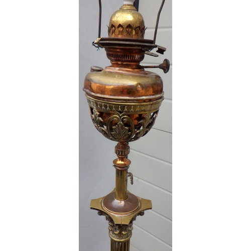 899 - A telescopic brass standard lamp with later oil lamp