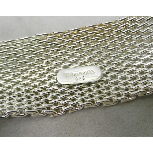 103 - A Milanese mesh bracelet, white metal having inner rectangular tag with rounded ends bearing the une... 